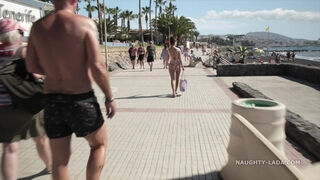 Busty MILF is walking almost naked on the public beach making everyone blush